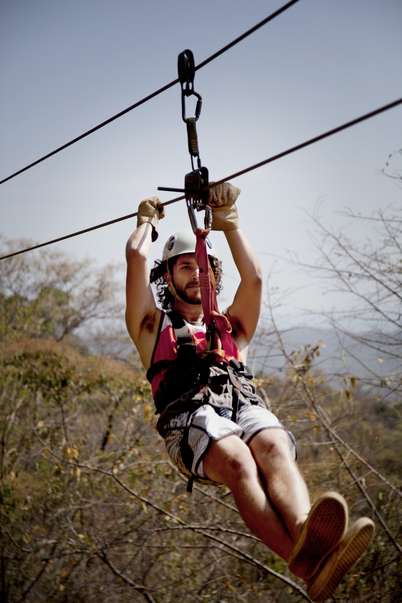 Man Zip Lining Against Sky In Forest